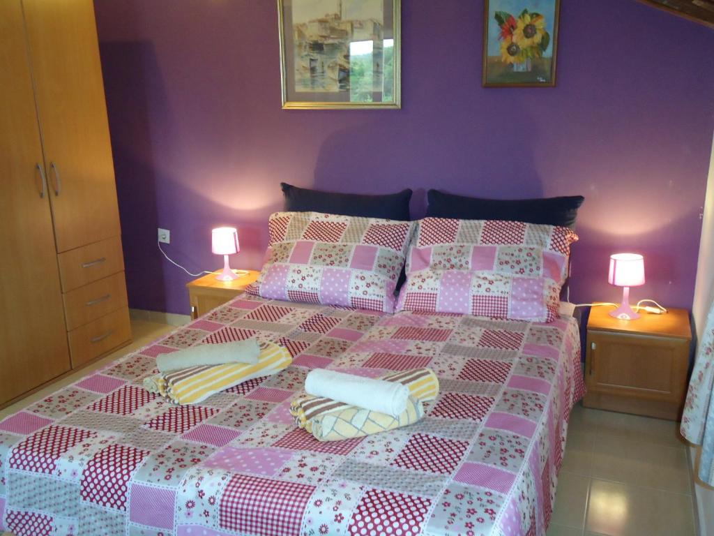a pink bedroom with a bed with two lamps at Studio Apartment Nera in Rovinj