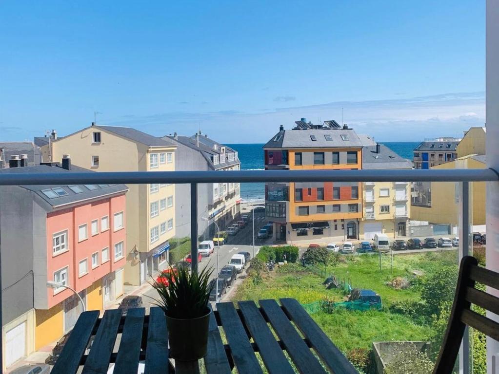 einen Balkon mit einer Bank und Stadtblick in der Unterkunft Apartamentos la Marosa in Burela