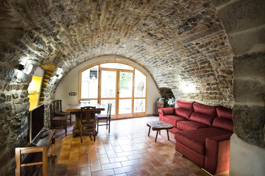 uma sala de estar com um sofá vermelho e uma mesa em Casa rural La Masadría em Mondot