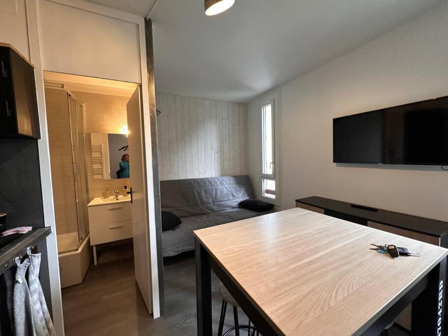 une chambre avec une table et une chambre avec un lit dans l'établissement Studio Guzet-Neige, au pied des pistes, à Ustou
