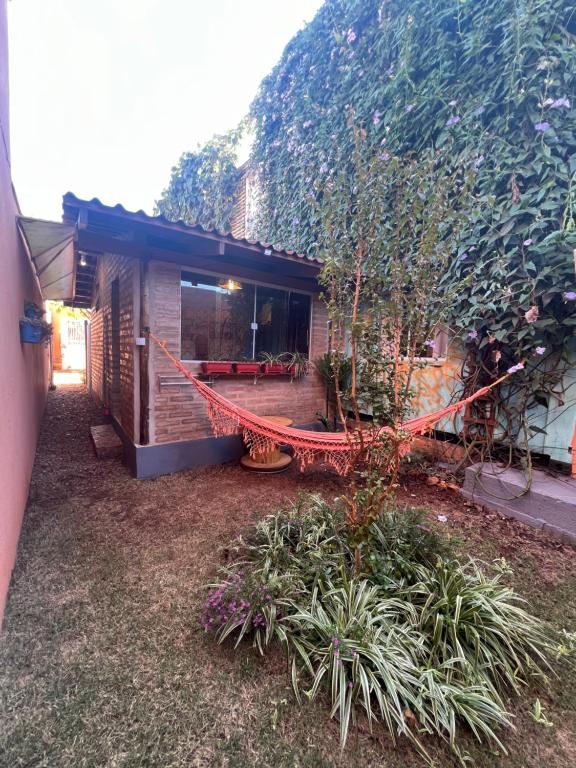 a house with a hammock in front of a yard at Casinhas no Contêiner dos Cristais in Delfinópolis