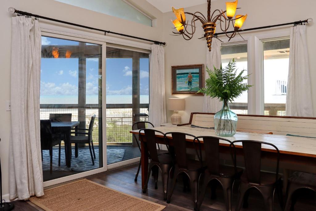 a dining room with a table and chairs and a view of the ocean at WindScape by Pristine Properties Vacation Rentals in Indian Pass