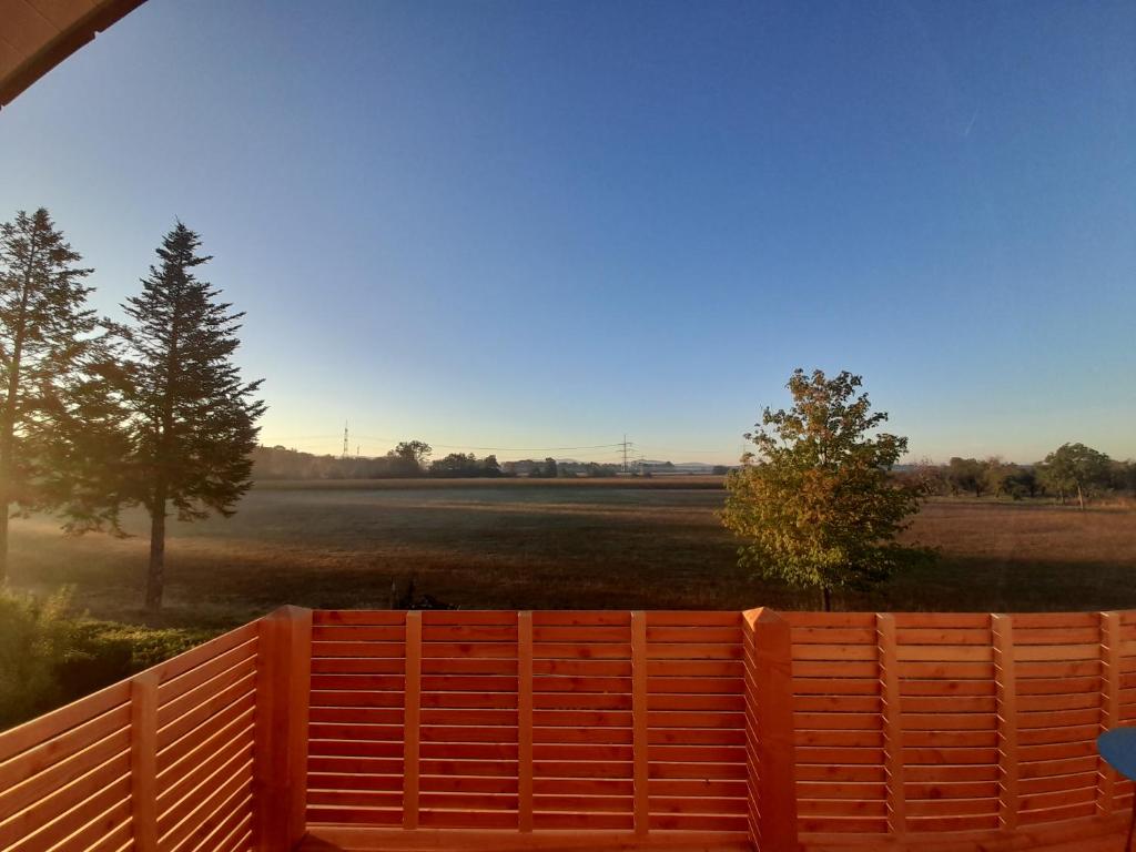 an orange fence with a field in the background at Badischer Neubau-Ruhe-Kunst-Natur in Rheinau