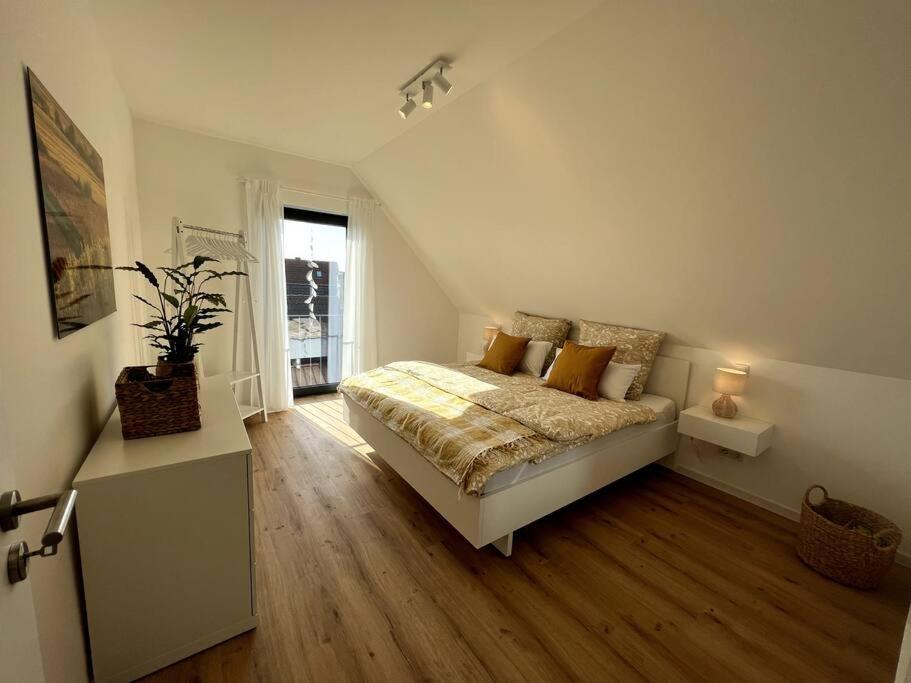 een witte slaapkamer met een bed en een raam bij Rückzugsort im Rebenmeer mit Grill & Parkplatz in Venningen