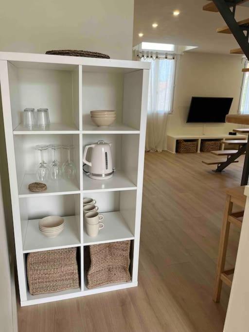 une étagère blanche avec des bols et des plats dessus dans l'établissement Duplex bord de mer La Madrague, à Marseille