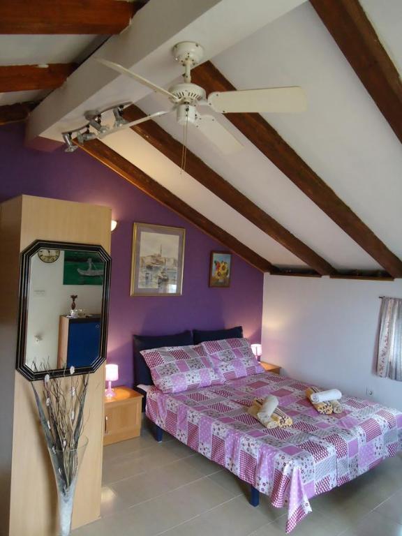 a bedroom with a bed with purple walls and a ceiling at Studio Apartment Nera in Rovinj
