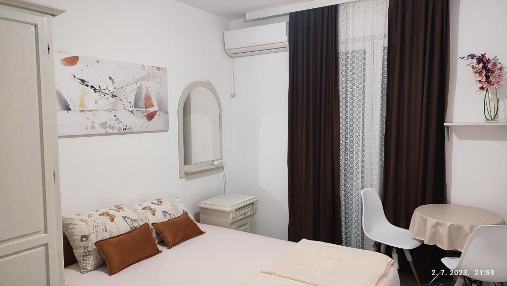 a small bedroom with a bed and a table at Pejovic Guest House in Sutomore
