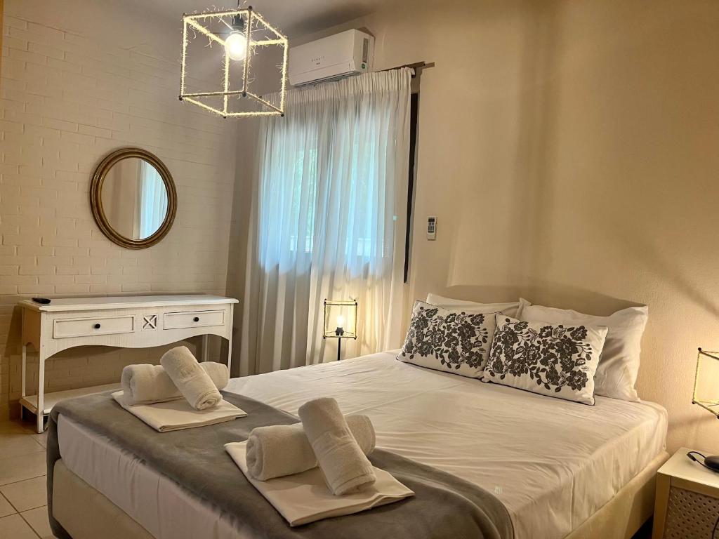 ein Schlafzimmer mit einem Bett mit zwei Handtüchern darauf in der Unterkunft The Beach House - Apartments & Studios in Afytos