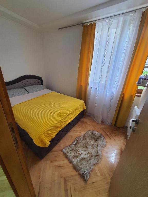a bedroom with a yellow bed and a window at Apartman Teddy12-Vlašić in Vlasic