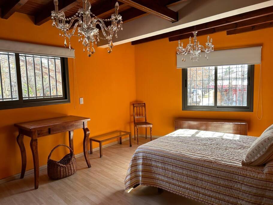 1 dormitorio con cama, mesa y ventanas en Departamento en Vistalba, Lujan con vista a la Montaña en Luján de Cuyo