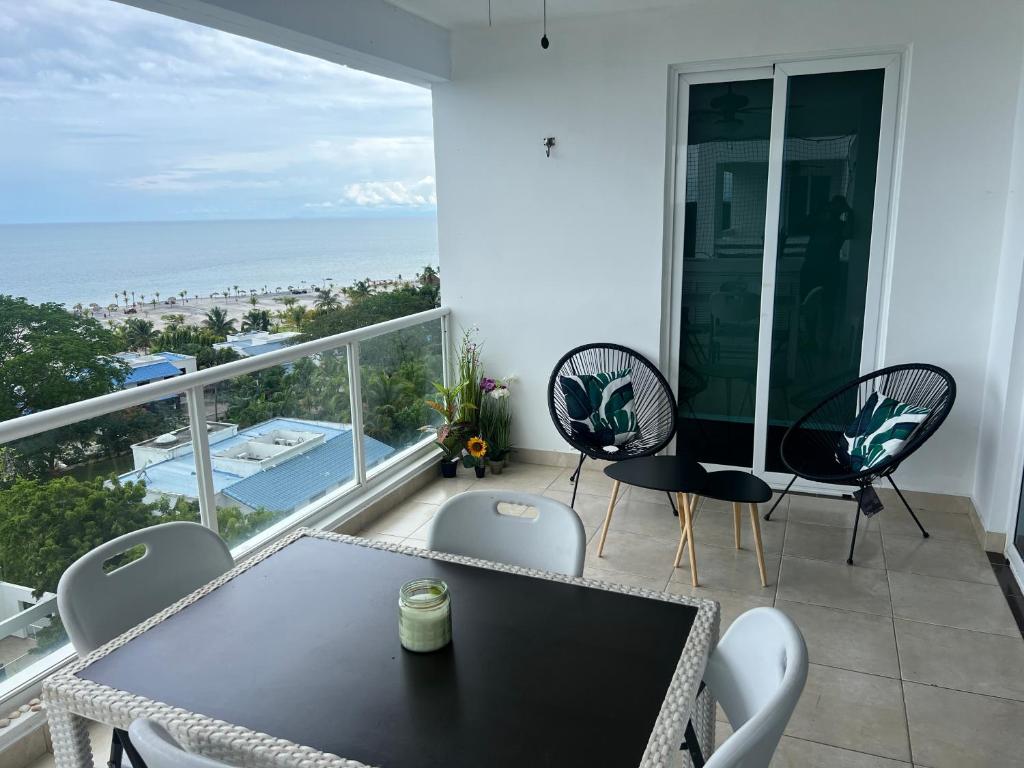 a balcony with a table and chairs and the ocean at Playa Blanca Beach front Condo in Río Hato