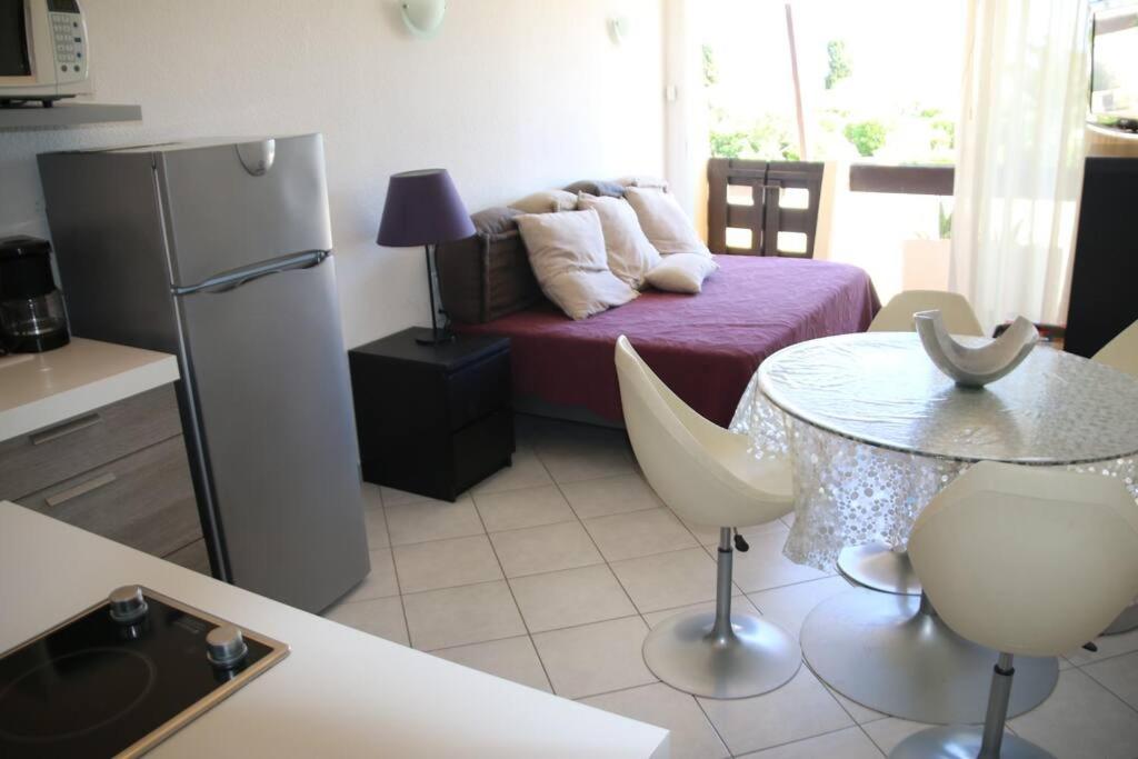 - une cuisine avec un lit, une table et un réfrigérateur dans l'établissement Studio 717, Port Nature 7 au village naturiste, au Cap d'Agde