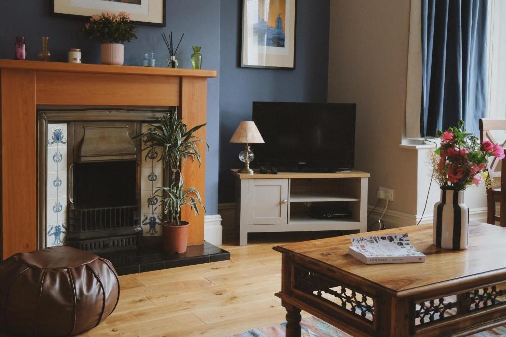 sala de estar con chimenea y TV en A cosy garden flat in a quiet area close to the city centre en Bristol