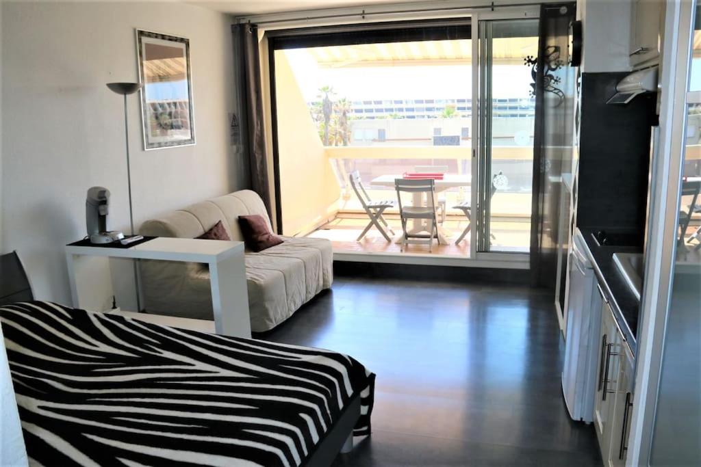 - un salon avec un canapé à motifs zébrés et une table dans l'établissement Studio 321, Héliopolis AB au village naturiste, au Cap d'Agde