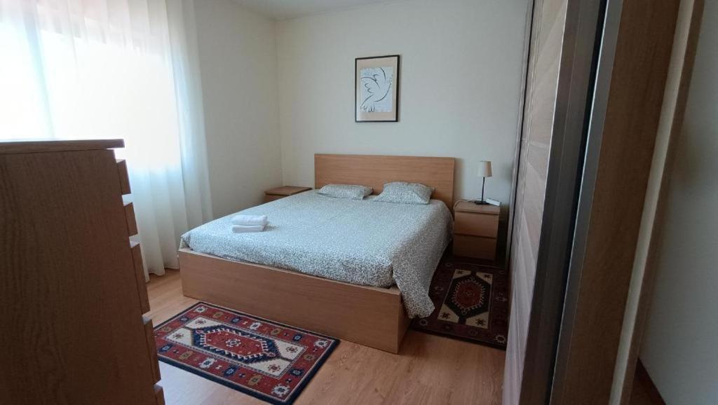 um pequeno quarto com uma cama e um tapete em Palmeiras em Arcozelo