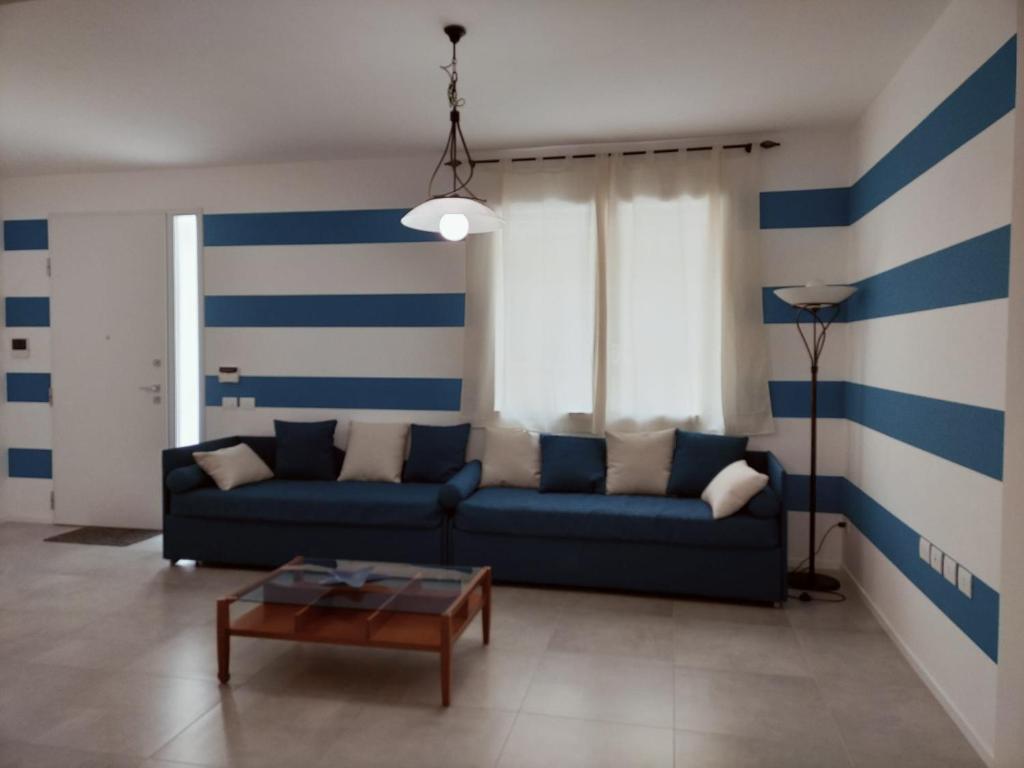a living room with a blue and white striped wall at Appartamento Stella Marina in Senigallia