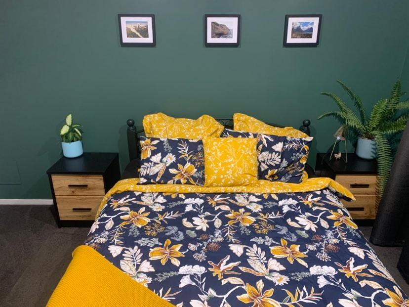 a bedroom with a bed with yellow and blue flowers at Hall Street Haven in Te Awamutu