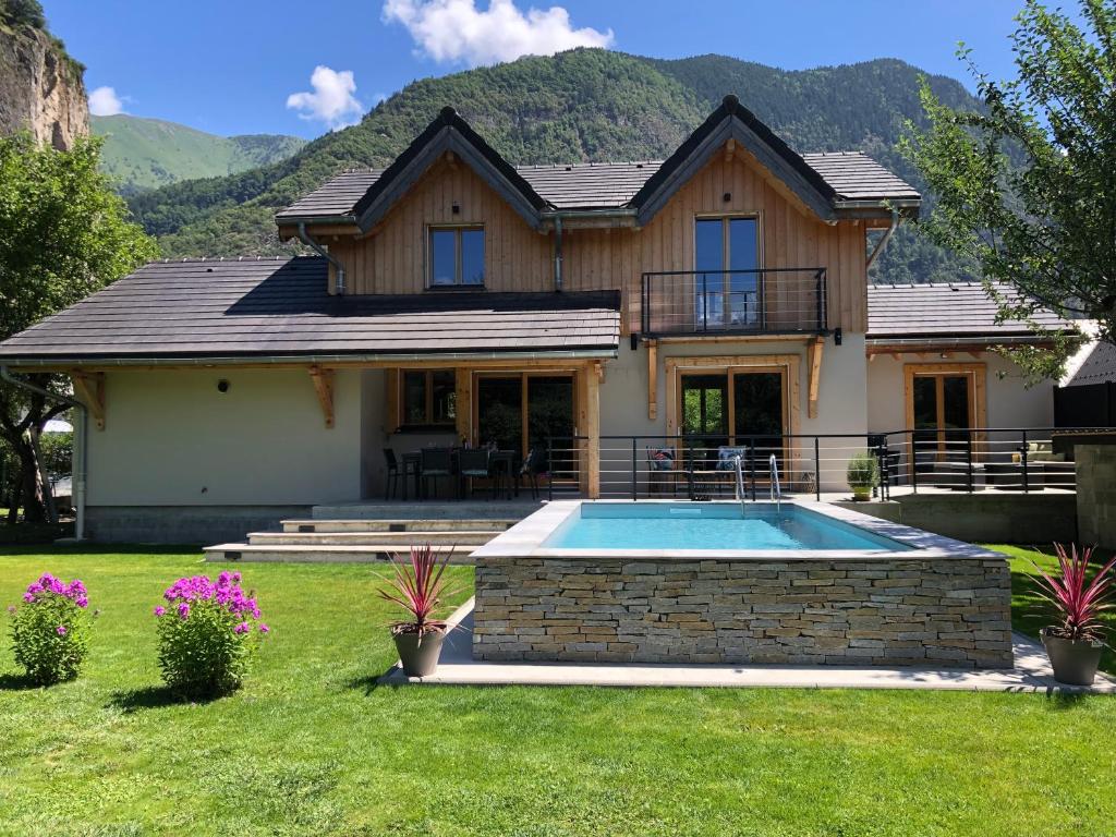 een huis met een zwembad in de tuin bij Chalet Barbara with swimming pool in the heart of Oisans in Le Bourg-dʼOisans