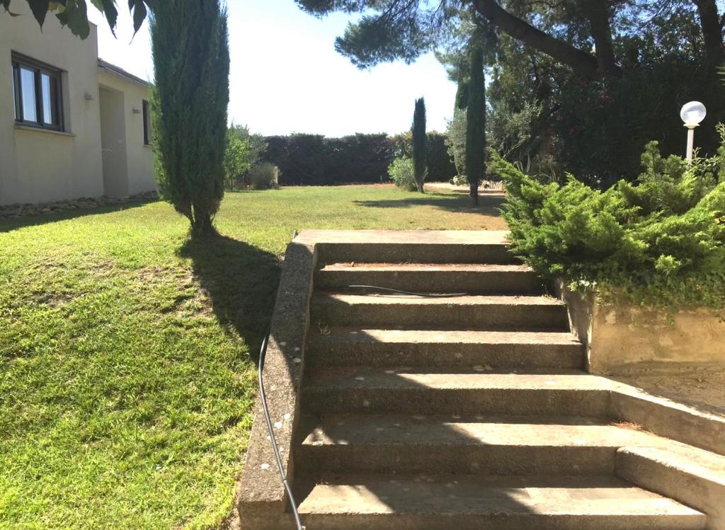 een trap in een tuin naast een huis bij Maison climatisée, 3 chambres, 2 étoiles, tout confort in Noves