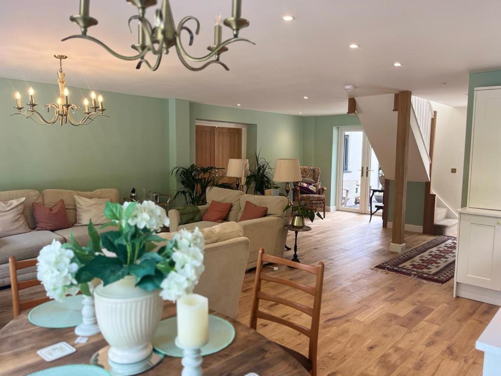 a living room with a couch and a table with flowers at The Croft in Cowbridge