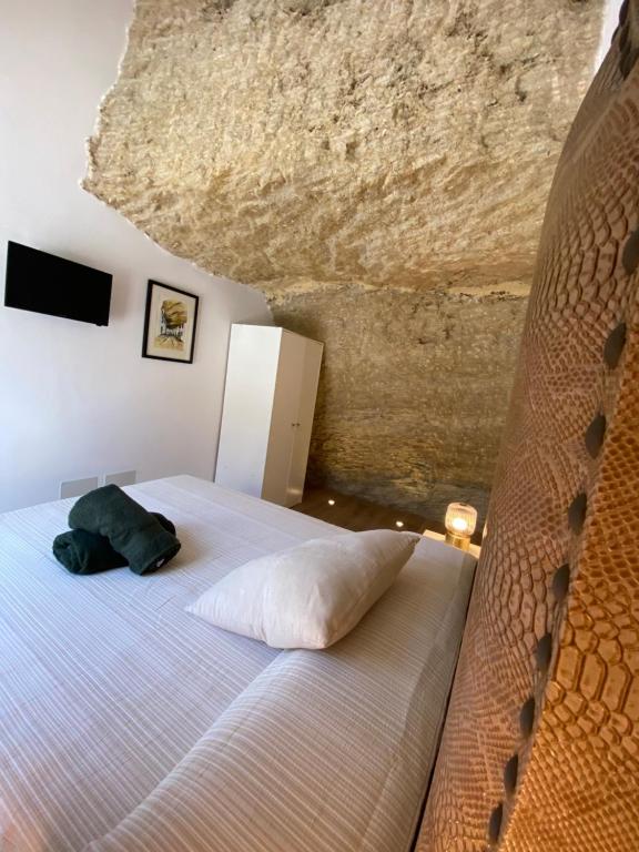 1 dormitorio con 1 cama grande y techo de roca en Casa Cueva “El Refugio en la Cueva”, en Setenil