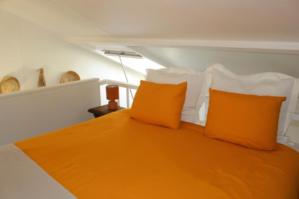 een slaapkamer met een oranje bed en 2 oranje kussens bij La Casita Middelburg in Middelburg