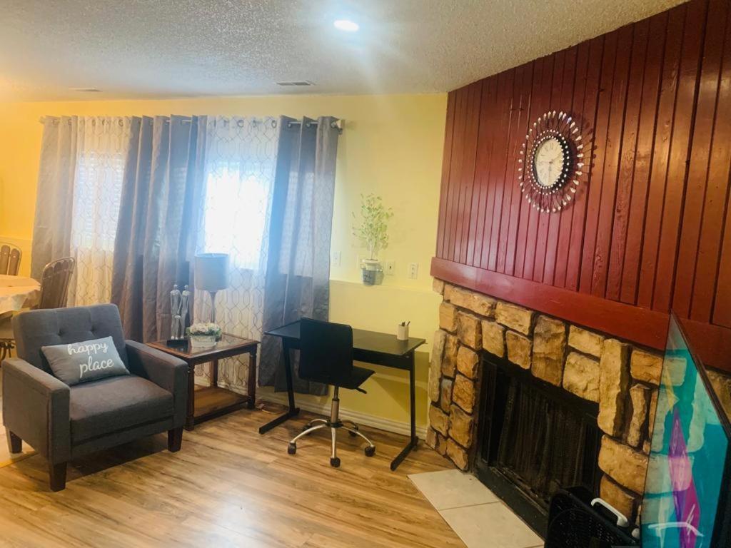 a living room with a fireplace and a chair and a desk at Luxury 2 bedroom rental place with a fireplace in Colorado Springs