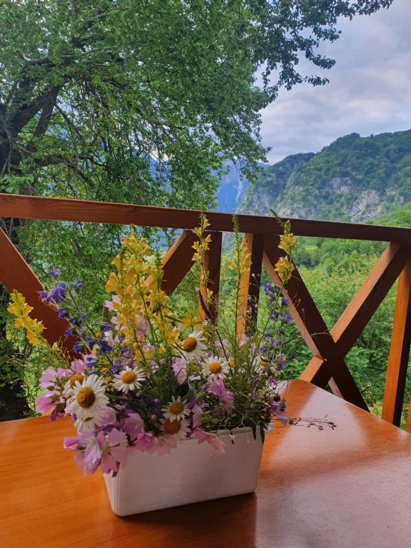 un jarrón de flores sentado en una mesa de madera en Villa Davisol, en Theth