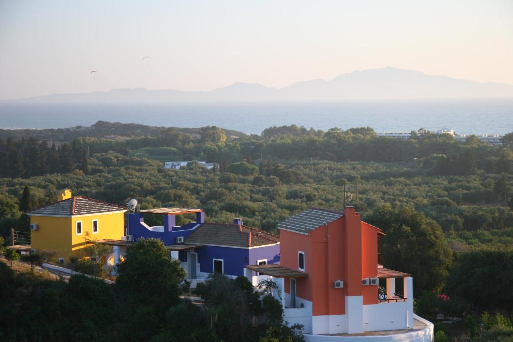 ein Haus auf einem Hügel mit dem Ozean im Hintergrund in der Unterkunft Ilis Villas in Kyllini