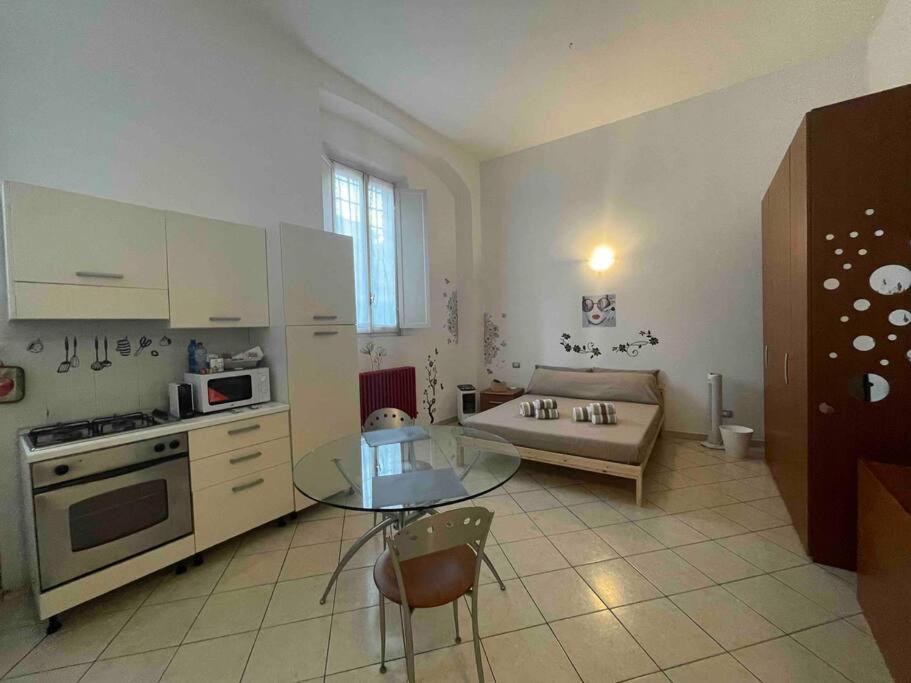 eine Küche mit einem Glastisch und einem Sofa in der Unterkunft Minimal Loft in centro a Piacenza in Piacenza