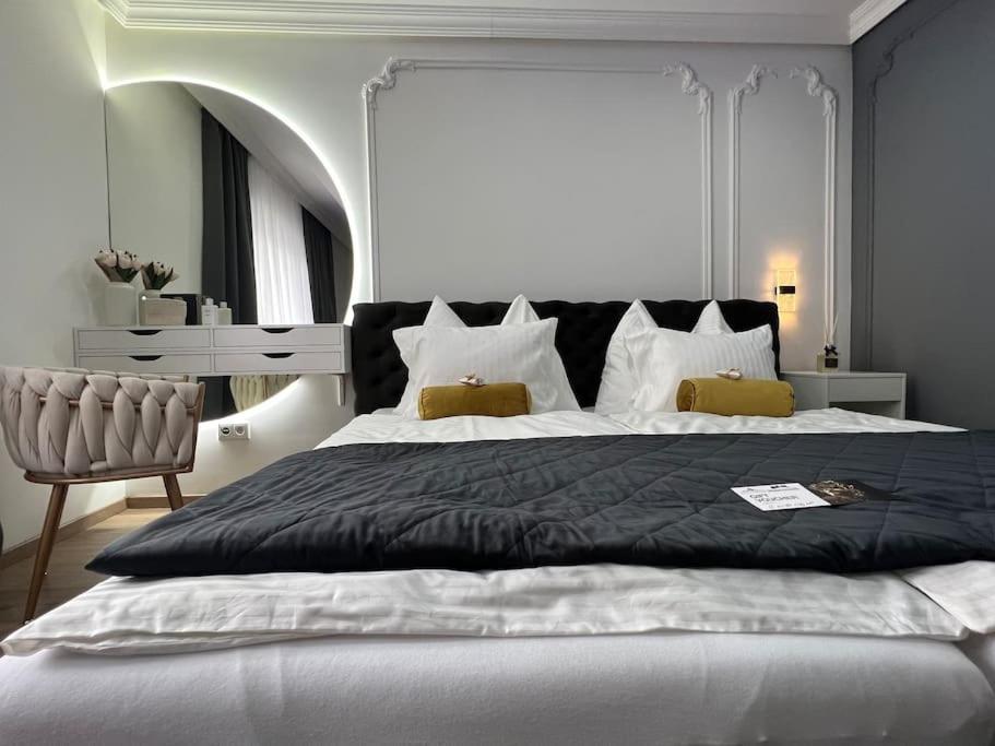 een slaapkamer met een groot bed en een stoel bij Traum Wohnung mit Kingsize-Bett in Graz