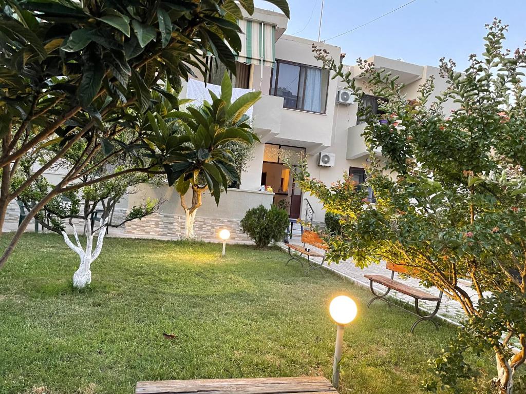 un patio con dos bancos y un edificio en Mabel Rooms, en Durrës