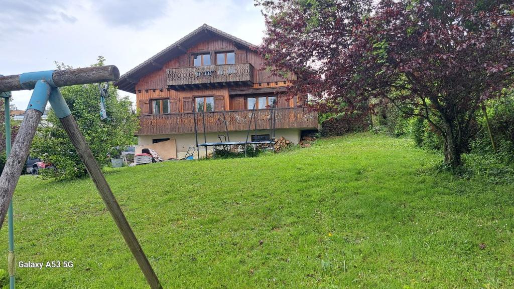 una casa en la cima de una colina con un campo verde en Chalet complet, en Cruseilles