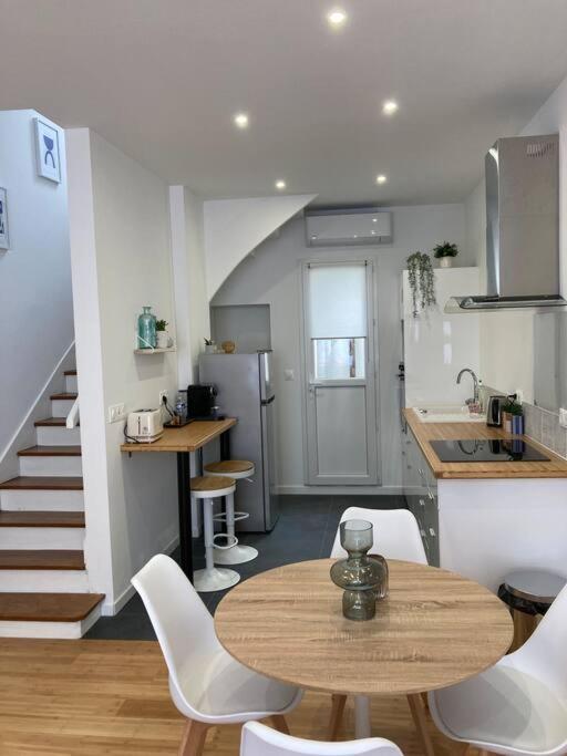 une cuisine avec une table et des chaises ainsi qu'un escalier dans l'établissement La Petite Maison, à Châteauroux