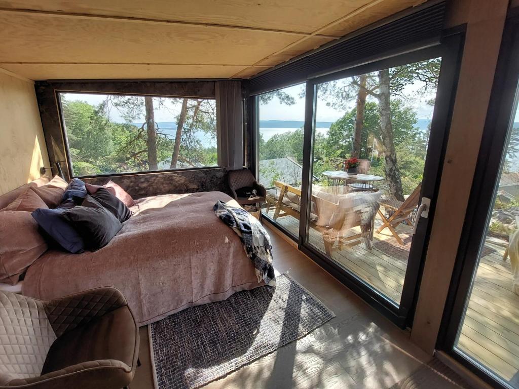 een persoon op een bed in een kamer met een groot raam bij fjord : oslo 