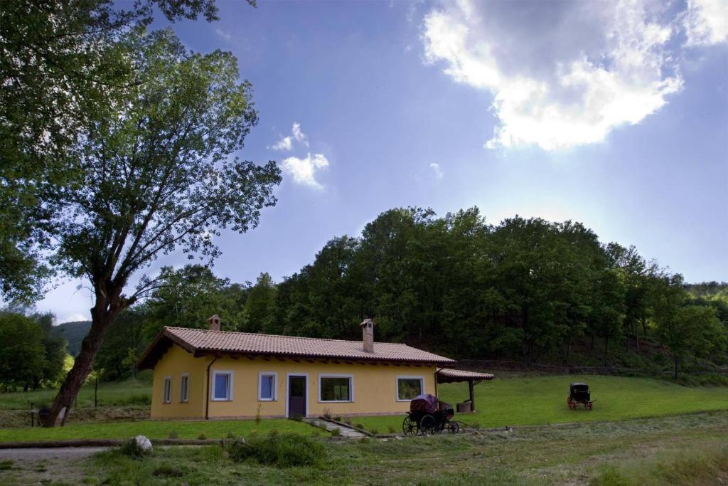 una casa gialla con due cavalli davanti di Agriturismo Borgo Serafino a Mangone