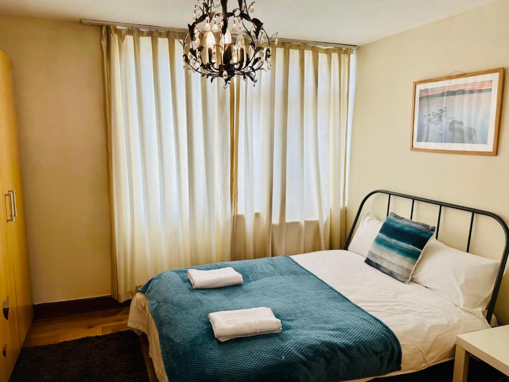 - une chambre avec un lit et 2 serviettes dans l'établissement London Mackenzie Apartment, à Londres