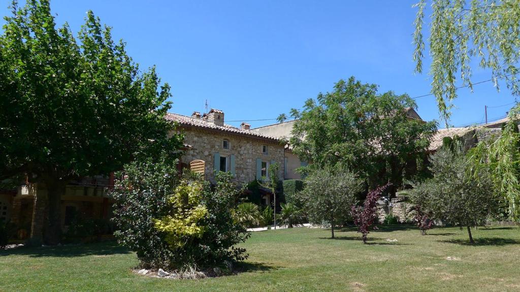 an old stone house with trees in the yard at Gites au Château des Estubiers in Les Granges-Gontardes
