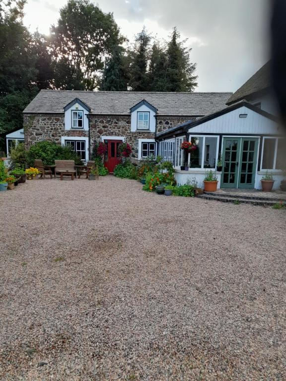 ein Haus mit einer roten Tür und einem Kieshof in der Unterkunft Moira Cottages at Berwickhall Sleeps 8 in Moira