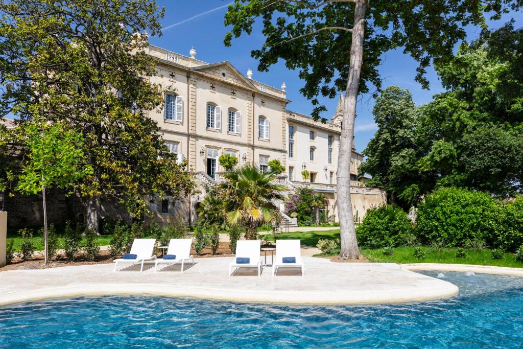 Collias的住宿－Château de Collias，一座带躺椅的游泳池和一座建筑