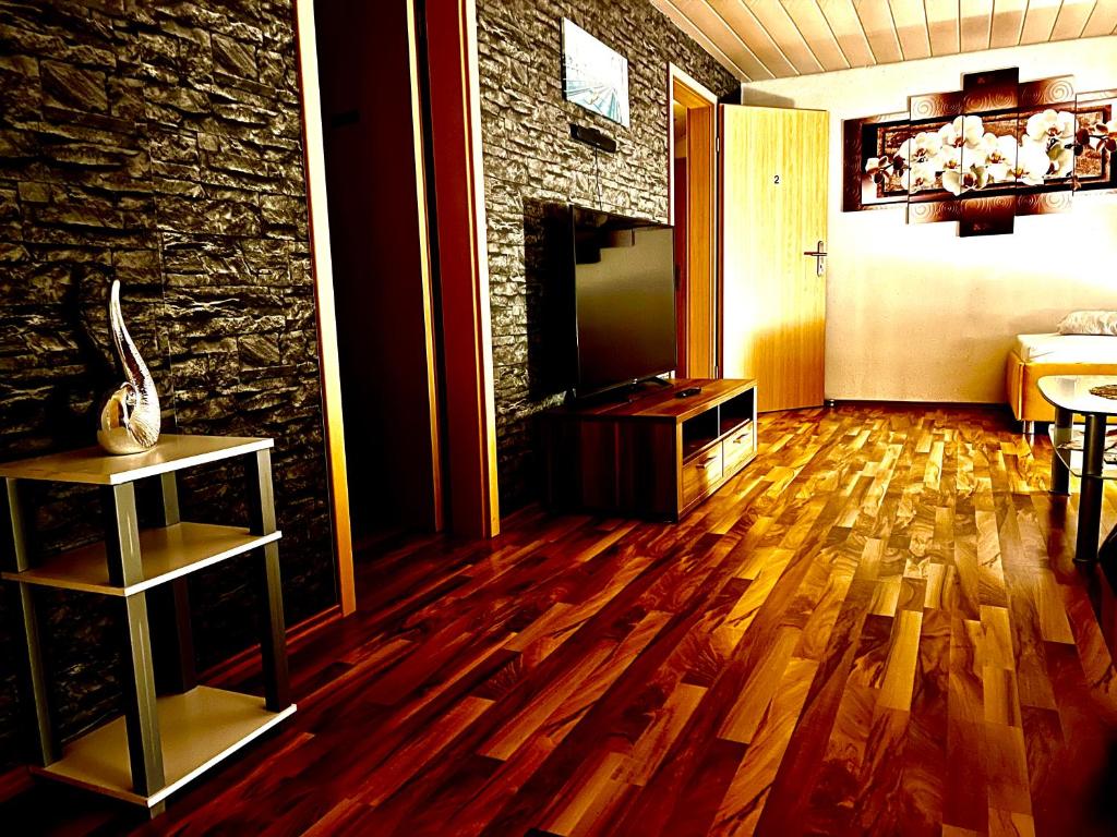 金策爾紹的住宿－DreamHouse Apartments，客厅铺有木地板,设有石墙。