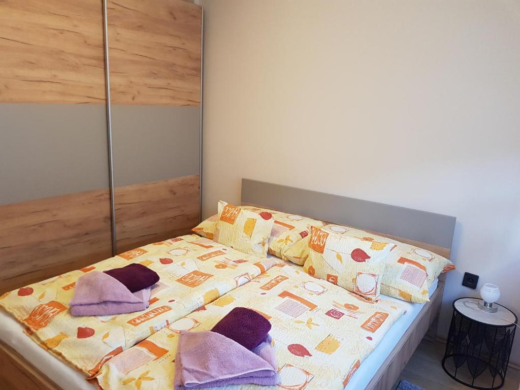 a bed with pillows on it in a bedroom at Henrietta Apartmanház in Zalakaros