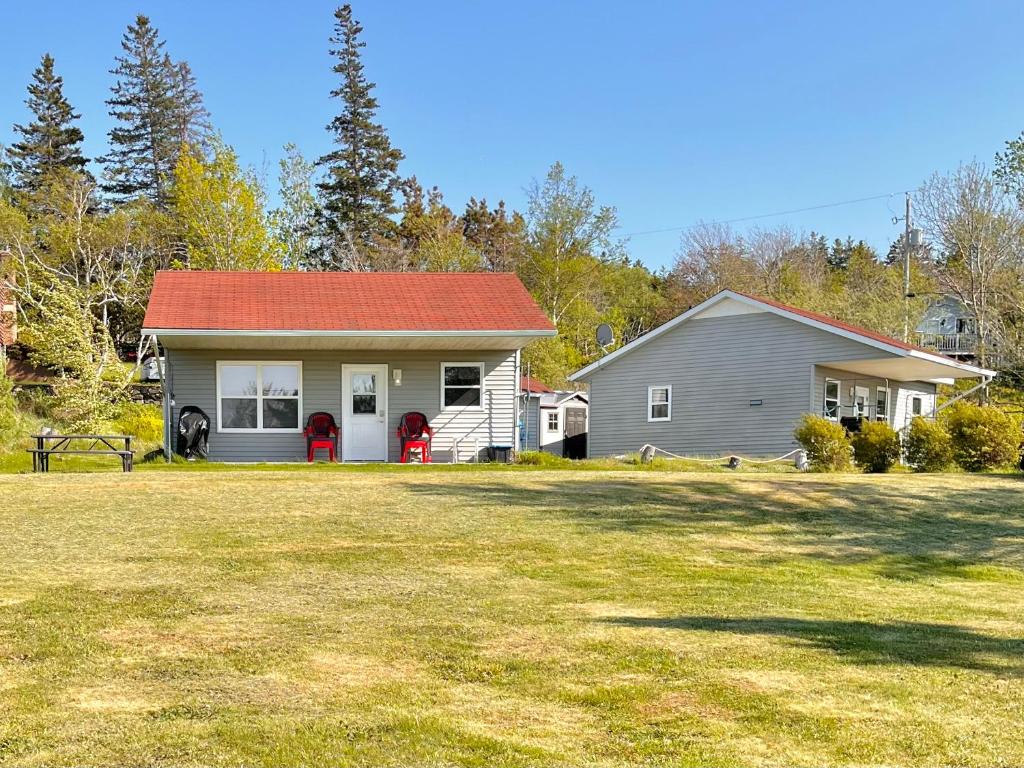 a house with a red roof and a yard at Stargazers Cove Cottages Blue Heron in Middleton