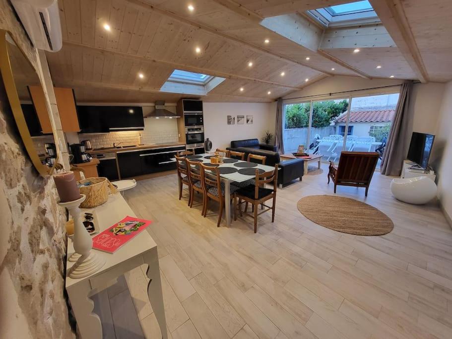 une cuisine et un salon avec une table et des chaises dans l'établissement Maison proche plages, port et tous commerces, à Les Sables-dʼOlonne