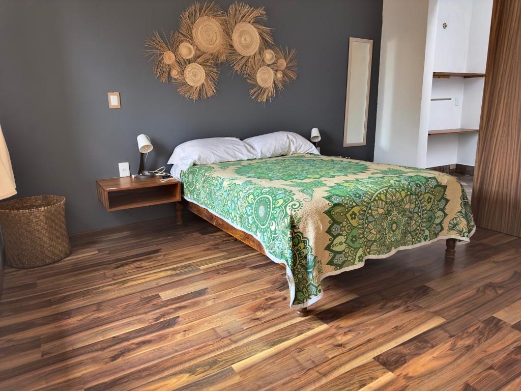 帕茨誇羅的住宿－Casa San Pancho Centro Mágico，一间卧室配有一张床,铺有木地板