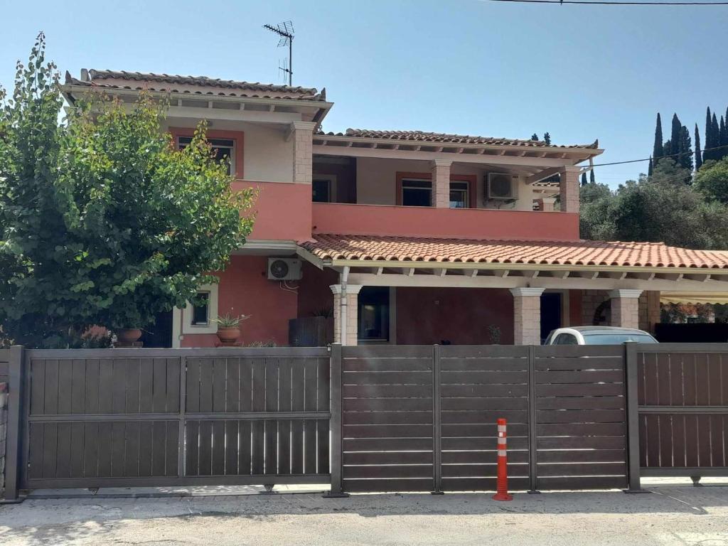 uma casa com uma cerca de madeira em frente em Apricot garden em Kynopiástai