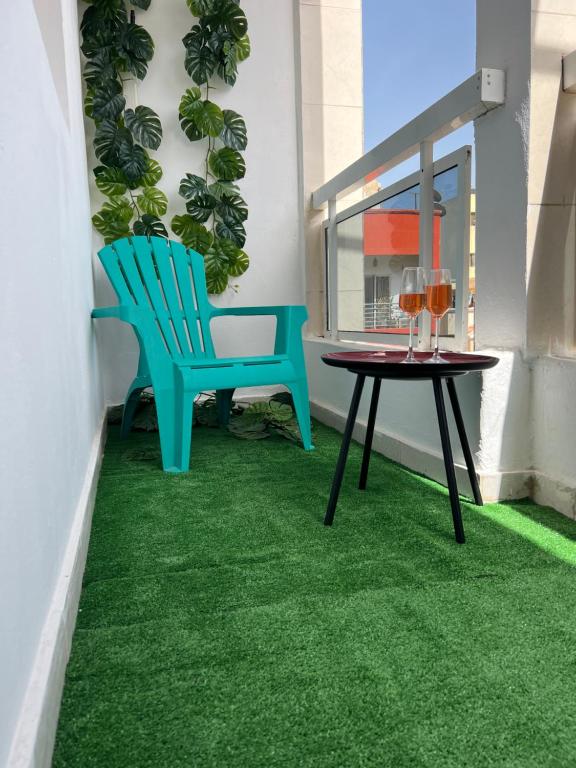 balkon ze stołem, krzesłami i zielonym dywanem w obiekcie The coolest room w mieście Rufisque