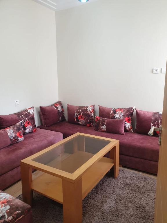 a living room with a red couch with a coffee table at Tamaris résidence janat saada in Tamaris