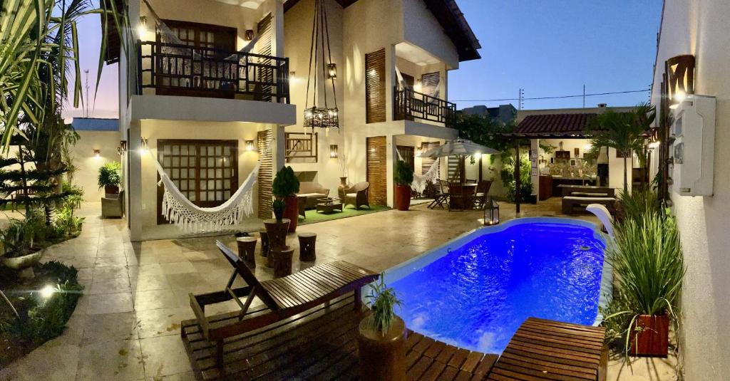 uma casa com piscina em frente a uma casa em Recanto Maria Flor em Flecheiras
