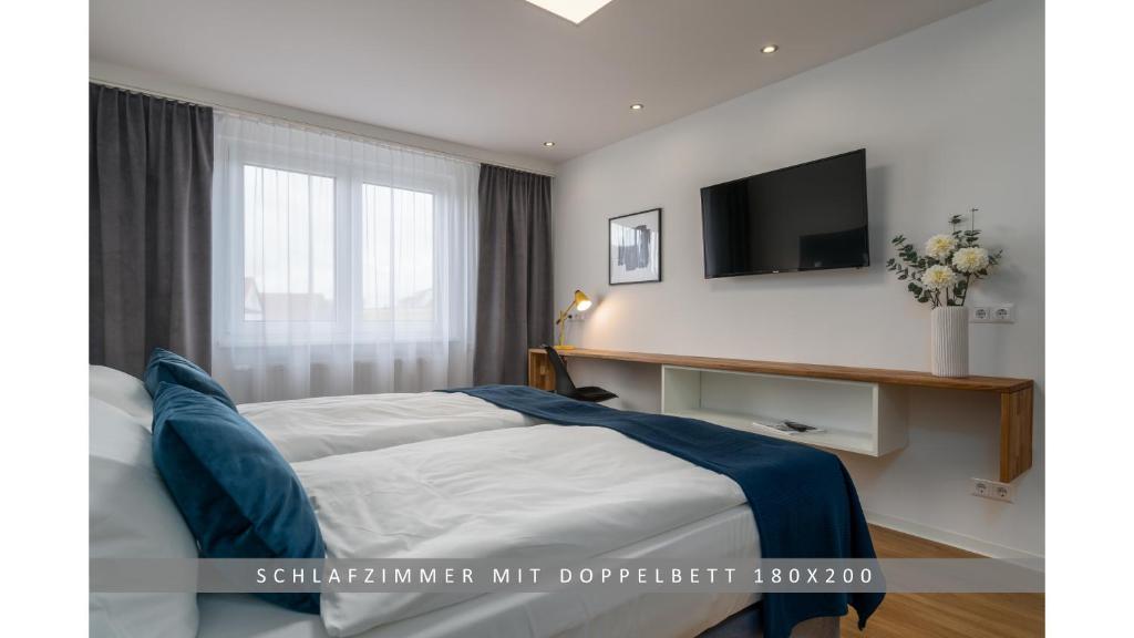 um quarto com uma cama e uma televisão na parede em Apartment Leinetal, mit Kamin, Seenähe, Harz Nähe em Northeim